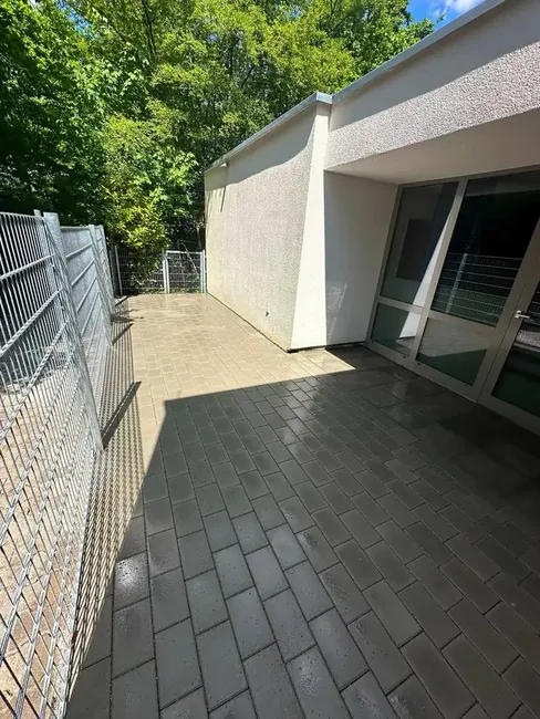 Frisch gepflasterte Terrasse mit Metallzaun