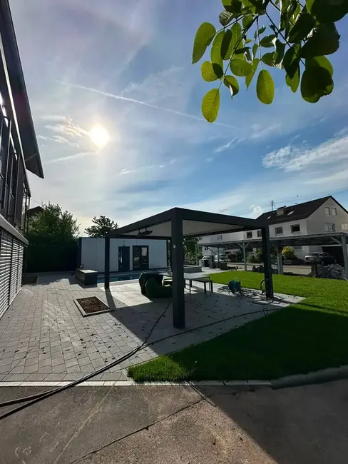 Poolterrasse mit Pergola und frischem Rasen