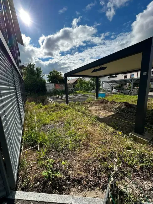 Verwilderte Fläche mit Carport vor dem Umbau